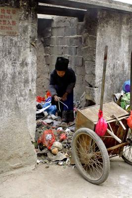 Hmong (Miao) elder picking through garbage for recyclables.