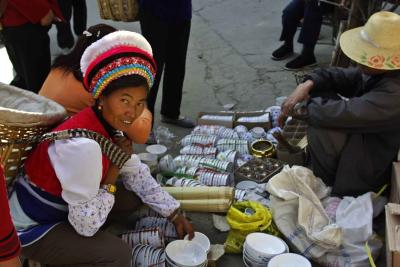 Bai woman in market place purchasing bowls Dali China .jpg