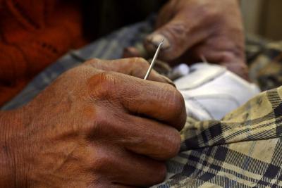 Shoe repairman with awl in hand. Dali, China.