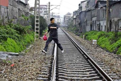 Crossing the tracks with the train coming on fast.  Jishou City, China.