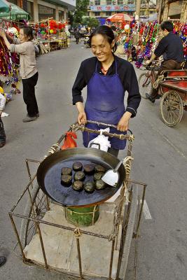 Selling glutinous (sticky) rice with Artemisia (sage). Street market.