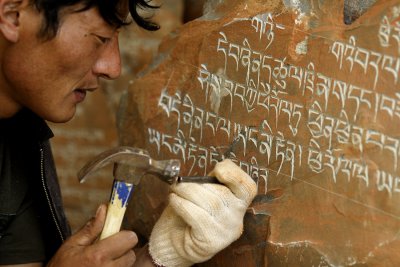 Carefully carving religious stones.