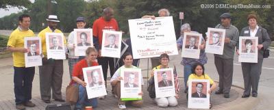 Holding up Pictures of the Board Members of Exxon Mobil