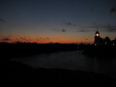 The sun sets behind an 'American' lighthouse, with Mt Fuji in the background.