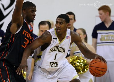 Jackets G Shumpert protects the ball from the tight defense of Canes G Brian Asbury