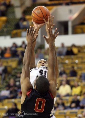 Jackets G Rice takes a jump shot over the outstretched arms of Trojans F Johnson