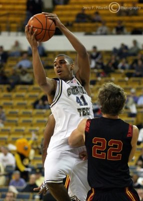 Yellow Jackets G Rice makes a pass over Trojans F Evan Smith