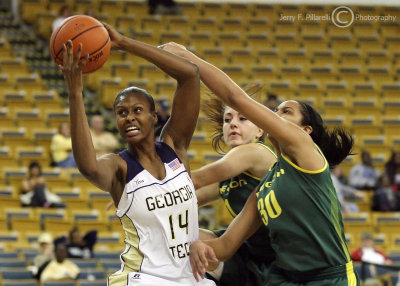 Yellow Jackets C LaQuananisha Adams fights for control of the ball with Ducks G Lilley and G Holliday