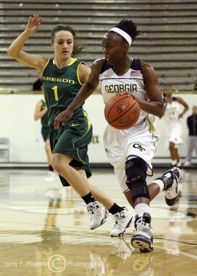 Jackets G Bennett streaks by Ducks G Lilly on her way to the basket