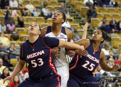 Yellow Jackets F Alex Montgomery is flanked by Wildcats F Lucet and G Thomas as they anticipate a rebound