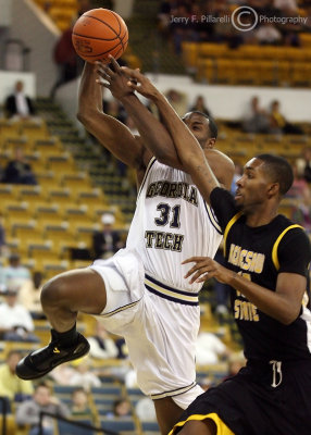 Jackets F Lawal drives past Owls F LaDaris Green on his way to the basket