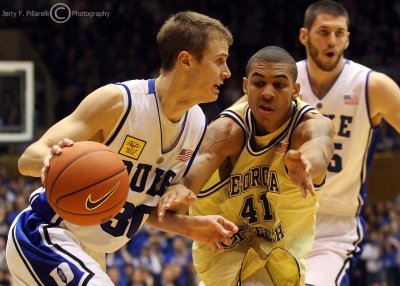 Jackets G Rice tries to stop a driving Blue Devils G Scheyer along the baseline