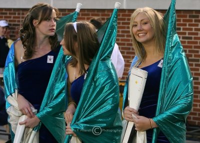 Yellow Jackets drill team members use their flags to keep themselves warm