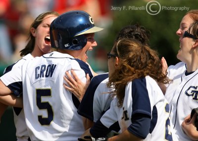 Yellow Jackets 2B Crow is mobbed by teammates after she scores the go-ahead run
