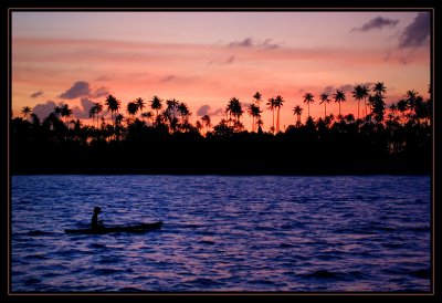 Villager paddling by at sunset