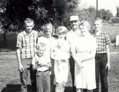 The original copy of this shot reads, Oct 1965. From left to right we can see, Roy Raymond, David Arthur, Donna Lou, JoAnne Esther, (holding Sharolynn Ann Macomber) Harold Everette, Harold Everett Robinson II, & Lucille Alena [Mattson] Robinson. This shot was donated by Harold's daughter, Amy Lynn [Robinson] Piar.