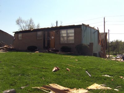 This little house had its roof shaved free & spread across the front yard. Even thirty six hours later, we were stepping over insulation & plyboards strewn about the sidewalk & street.