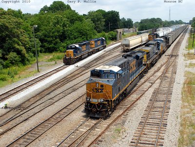 A hopper train passes yard power at Monroe NC.jpg