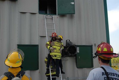 Instructors demonstrate bringing a firefighter down a ladder