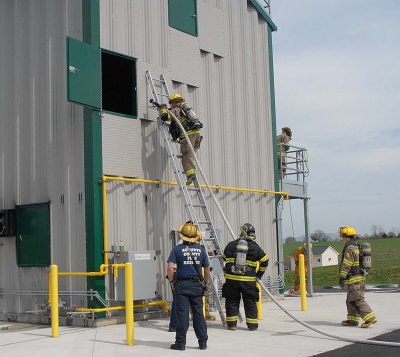 Taking a hose line up a ladder