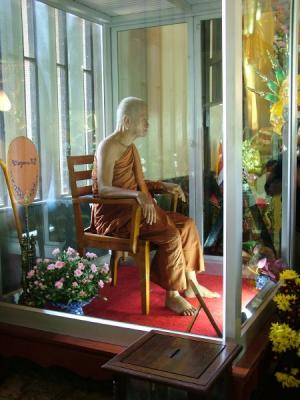 Monk in meditation in glass box