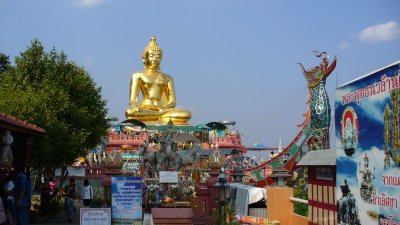 Down on the river, we take a long tail boat from this shrine to a Laotian island.