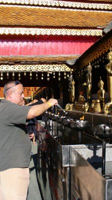 Pierre feeds the flame in front of the meditating Buddha statue, the symbol for those born on a Thursday.