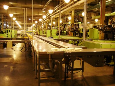 An conveyor belt that the (very hot) pieces of TW just turned out of the molds rolls along to shipping, allowing the pieces to cool as they go. These off-white pieces are the inside steamer to the tortilla keeper.