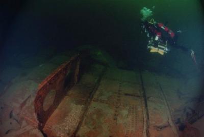 Diver Paul Crocker swimming over a section of cargo hold hull plating