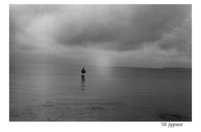 fisher on a glassy san carlos bay under a big gray sky
