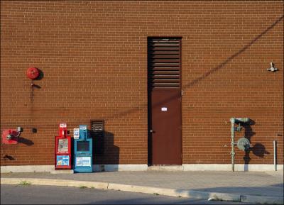 Newspaper boxes, industrial miscellany, and shadows