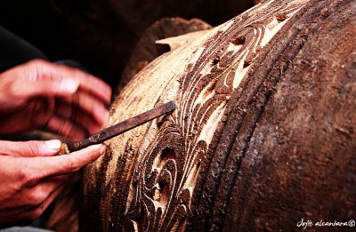 Wood carver at work on a drum