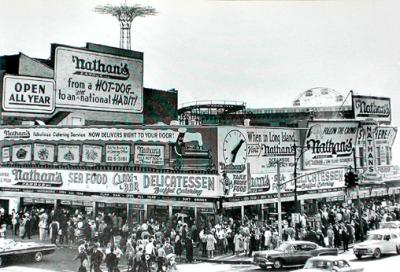Nathan's at Coney Island - famous for its hot dogs. The Parachute Jump  & the Wonder Wheel rides are in the background. (1950's)