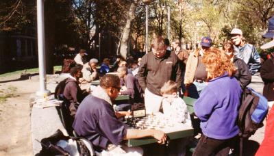 A kid challenges a veteran to a chess game in Washington Square Park, Greenwich Village - in Manhattan