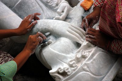 Myanamar women sand a marble Bouddha statue, Myanmar