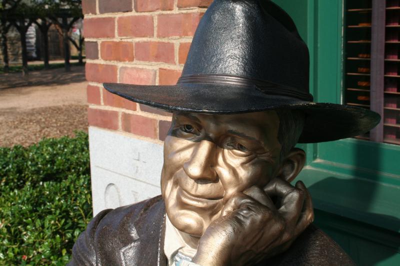 STATUE OF MAN SITTING ON A BENCH