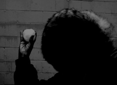 CIRCULAR SNOWBALL AND HEAD, TRIANGULAR HAND HOLDING THE SNOWBALL AND RECTANGLES IN THE BACKGROUND