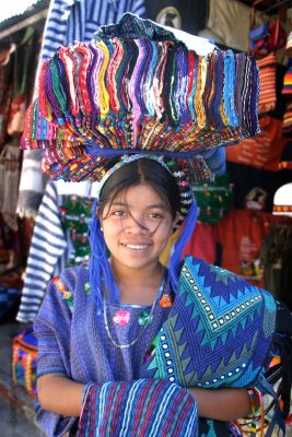 Las niñas vendedoras de artículos autóctonos de Panajachel, llevan toda su mercadería sobre sus cabezas.