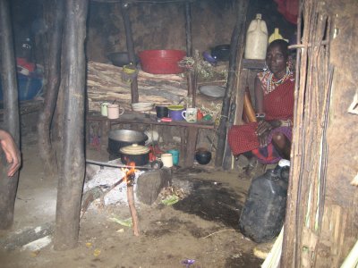 Inside Pemba's hut, his mother  heats milk for chai (tea).