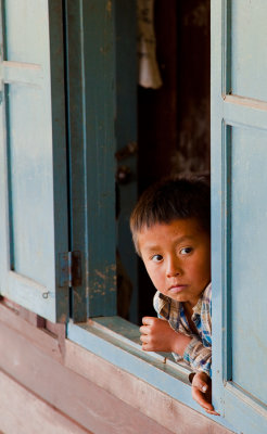 Laos boy peeking through window