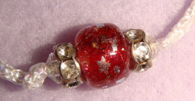  Silver colored stars on red beads-detail
