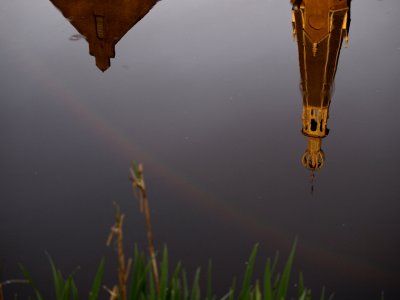 Reflectie van kerk en regenboog in het Westerdiep