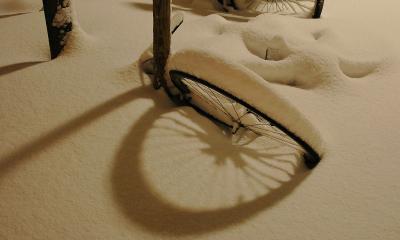 Cykel i sneen under en gadelampe