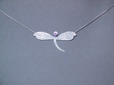 This dragonfly pendant is about 3.5 cm across, and features a 4mm amethyst. Sold