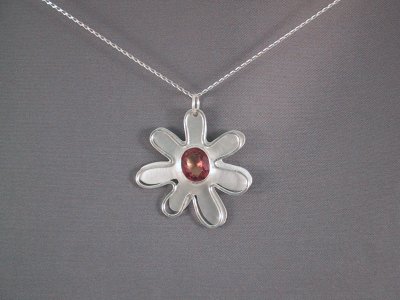 Floating flower pendant with a pink rhinestone in the centre. Sold