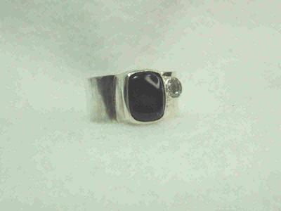 dark, tea-colored tourmaline set on a squred band with a colorless, faceted topaz for accent. SOLD
