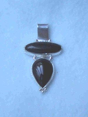 2 onyx stones set in decorative bezels with a few granules attached. Sold