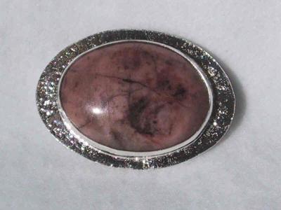 30 x 40 mm rhodonite stone set on a reticulated background.  this pin has loops on the back and can also be worn as a pendant.