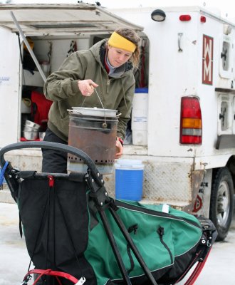 Loading Up Her Alcohol Musher Stove In The Sled