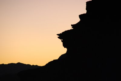 Sunset brings out the silhouette of a naturally wind-formed horse head in the rock wall.